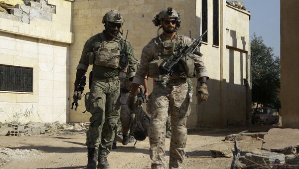 Armed men in uniform identified by Syrian Democratic forces as US special operations forces walk in the village of Fatisah in the northern Syrian province of Raqa on May 25, 2016 - Sputnik International