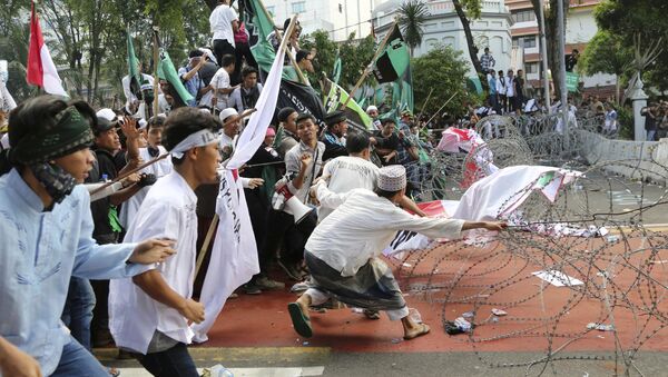Muslim protesters pull razor wire blocking a road that leads to the presidential palace during a rally against Jakarta Governor Basuki Tjahaja Purnama in Jakarta, Indonesia, Friday, Nov. 4, 2016. - Sputnik International