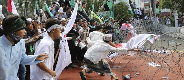 Muslim protesters pull razor wire blocking a road that leads to the presidential palace during a rally against Jakarta Governor Basuki Tjahaja Purnama in Jakarta, Indonesia, Friday, Nov. 4, 2016. Muslim protesters pull razor wire blocking a road that leads to the presidential palace during a rally against Jakarta Governor Basuki Tjahaja Purnama in Jakarta, Indonesia, Friday, Nov. 4, 2016. - Sputnik International