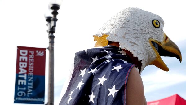 A man wears an eagle mask and is draped in a US flag outside of the event site of a U.S. presidential debate between Republican nominee Donald Trump and Democratic nominee Hillary Clinton at Washington University in St. Louis, Missouri, US, October 9, 2016. - Sputnik International