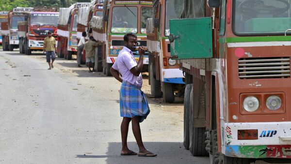 A truck driver brushes his teeth next to his parked truck while waiting to get his loads cleared to cross a checkpoint at the Commercial Taxes Department check post at Walayar in Palakkad district in southern Indian state of Kerala, India September 5, 2015 - Sputnik International
