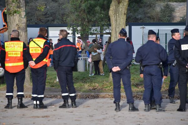 Migrant woman and children hug as they leave the Jules Ferry reception centre, next to the recently demolished Jungle migrant camp after a massive operation to clear the settlement, on November 3, 2016, in Calais - Sputnik International