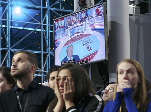 Supporters of Democratic presidential nominee Hillary Clinton watch and wait, with a Donald Trump image on a screen at rear, at her election night rally in New York, U.S., November 8, 2016 - Sputnik International