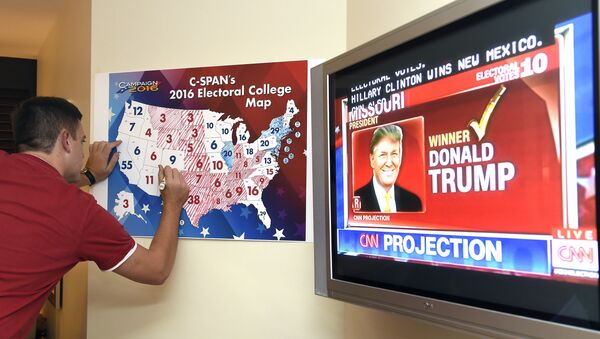 Jake Krupa colors in an electoral map as states projected for Republican presidential candidate Donald Trump or Democratic Presidential candidate Hillary Clinton at an election watching party in Coconut Grove, Florida, on November 8, 2016 - Sputnik International