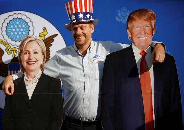 A man poses for a picture with the cardboard cutouts of US presidential nominees Hillary Clinton (L) and Donald Trump, at an election event hosted at the US ambassador's residence in Kathmandu, Nepal November 9, 2016. A man poses for a picture with the cardboard cutouts of US presidential nominees Hillary Clinton (L) and Donald Trump, at an election event hosted at the US ambassador's residence in Kathmandu, Nepal November 9, 2016. - Sputnik International