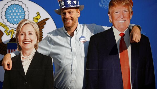 A man poses for a picture with the cardboard cutouts of US presidential nominees Hillary Clinton (L) and Donald Trump, at an election event hosted at the US ambassador's residence in Kathmandu, Nepal November 9, 2016. - Sputnik International
