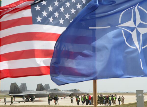 The US and The NATO flag flie in front of two US Air Force F-22 Raptor fighter aircrafts at the Air Base of the Lithuanian Armed Forces in Šiauliai, Lithuania, on April 27, 2016. The US and The NATO flag flie in front of two US Air Force F-22 Raptor fighter aircrafts at the Air Base of the Lithuanian Armed Forces in Šiauliai, Lithuania, on April 27, 2016. - Sputnik International