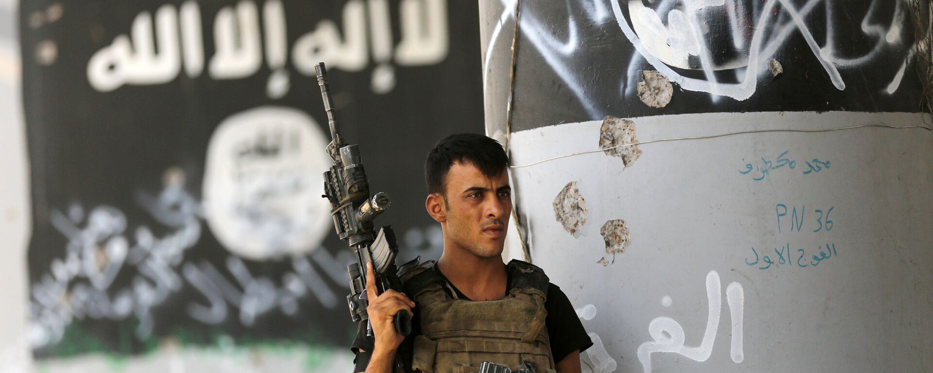 A member of Iraqi counterterrorism forces stands guard near Islamic State group militant graffiti in Fallujah, Iraq (File) - Sputnik International, 1920, 29.03.2024