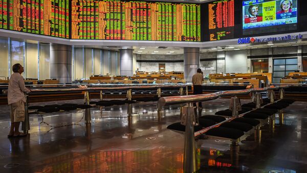 Traders monitor electronic boards showing stock movements during the final day of the US presidential election at a private stock exchange in Kuala Lumpur on November 9, 2016 - Sputnik International