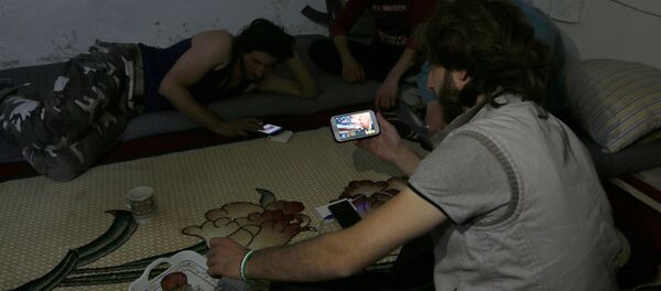 A Harakat Nour al-Din al-Zenki fighter watches news about Donald Trump's election as president on his smart phone in the rebel held beseiged area in Aleppo, Syria November 9, 2016 A Harakat Nour al-Din al-Zenki fighter watches news about Donald Trump's election as president on his smart phone in the rebel held beseiged area in Aleppo, Syria November 9, 2016 - Sputnik International