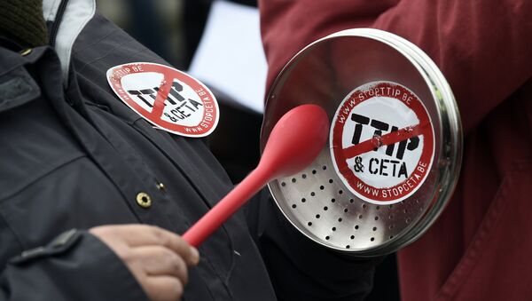A demonstrator holds a lid with a sticker reading TTIP & CETA crossed during a protest against the EU-Canada Comprehensive Economic and Trade Agreement (CETA) at European Union Commission headquarters in Brussels on October 27, 2016. - Sputnik International