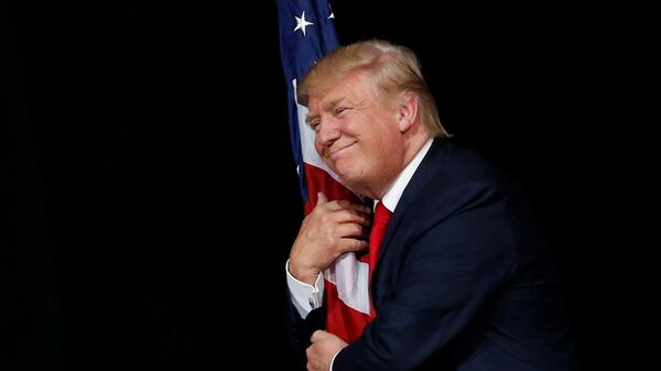 Donald Trump hugs a U.S. flag as he comes onstage to rally with supporters in Tampa, Florida, U.S. October 24, 2016 - Sputnik International