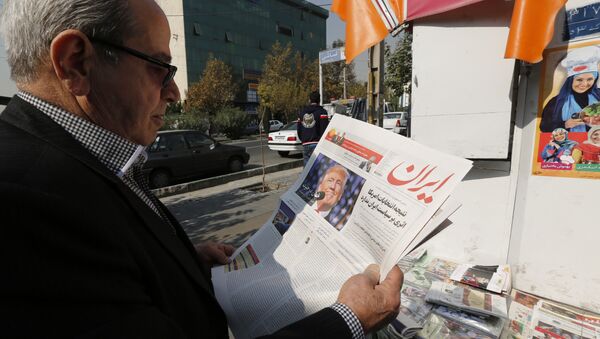An Iranian man holds a local newspaper displaying a portrait of Donald Trump a day after his election as the new US president, in the capital Tehran, on November 10, 2016 - Sputnik International
