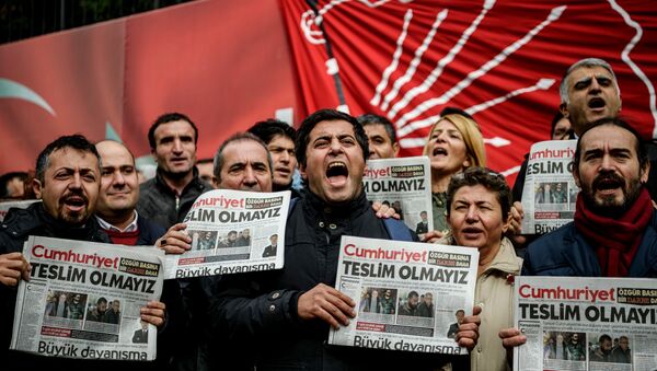 Protesters hold copies of the latest edition of the the Turkish daily newspaper Cumhuriyet as they shout slogans during a demonstration outside the newspaper's headquarters in Istanbul on November 1,2016 a day after its editor in chief was detained by police. - Sputnik International