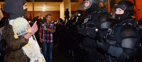 A protestor gestures at police at Pioneer Square in Portland, Oregon on November 11, 2016, to protest the election of US President-elect Donald Trump. A protestor gestures at police at Pioneer Square in Portland, Oregon on November 11, 2016, to protest the election of US President-elect Donald Trump. - Sputnik International