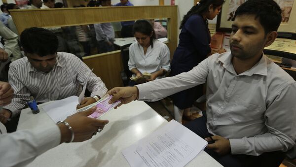 New Indian currency note of denomination 2000 is given in exchange of discontinued currency notes at a bank in New Delhi, India - Sputnik International