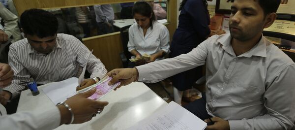 New Indian currency note of denomination 2000 is given in exchange of discontinued currency notes at a bank in New Delhi, India New Indian currency note of denomination 2000 is given in exchange of discontinued currency notes at a bank in New Delhi, India - Sputnik International