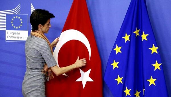 A woman adjusts the Turkish flag next to the European Union flag before the arrival of Turkish Prime Minister Ahmet Davutoglu (unseen) at the EU Commission headquarters in Brussels January 15, 2015. - Sputnik International