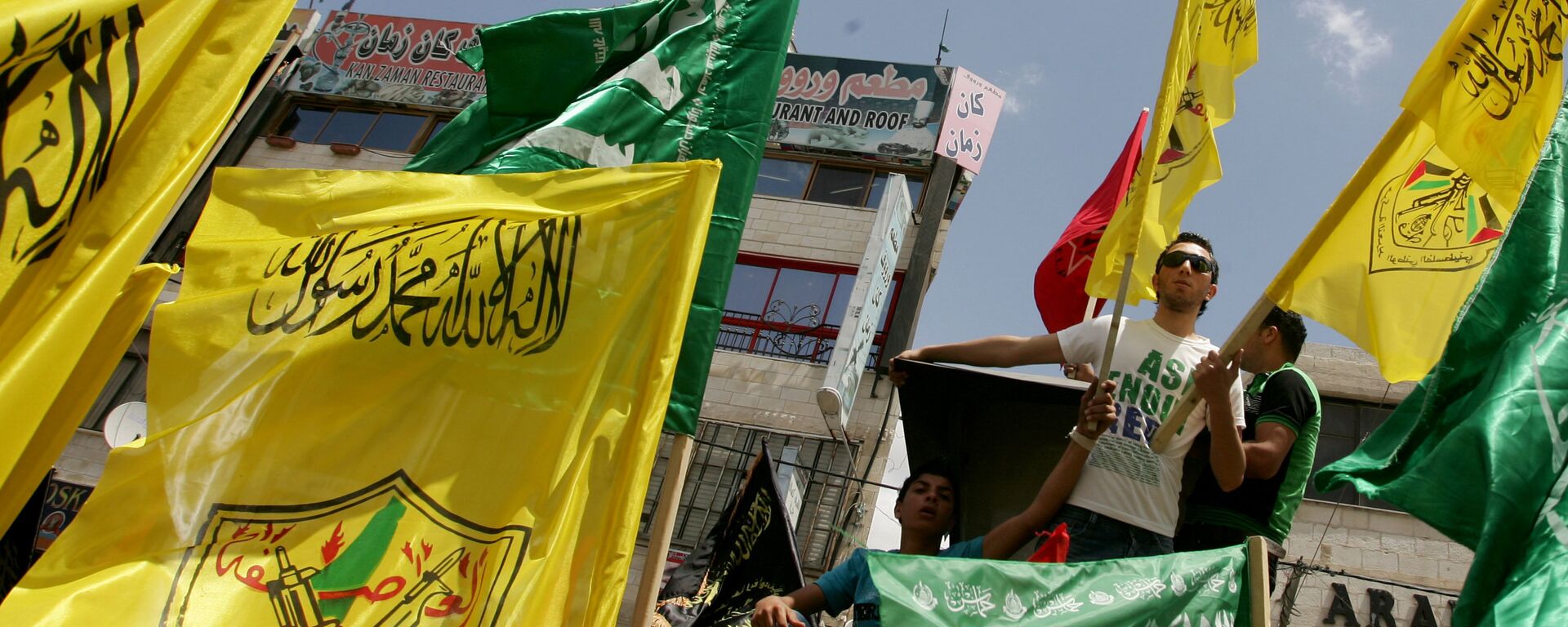 Palestinian supporters of Hamas Islamist movement and of Fatah party wave their faction's flags during a rally to support the Palestinian political unity deal, in the West Bank city of Jenin. (File) - Sputnik International, 1920, 09.05.2022