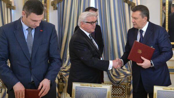 German Foreign Affairs minister Frank-Walter Steinmeier (C) and Ukrainian President Viktor Yanukovych (R) shake hands as head of Udar (Punch) party Vitali Klitschko attends after they signed the deal in Kiev on February 21, 2014 - Sputnik International