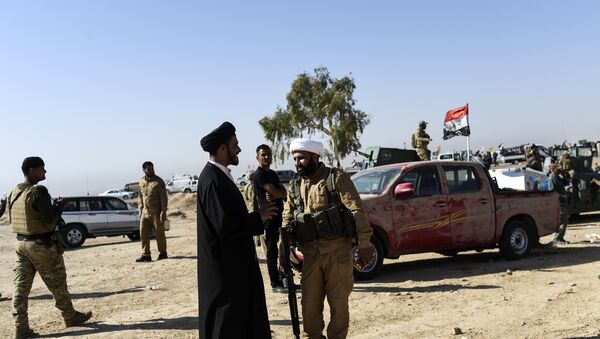 Members of Al-Hashd al-Shaabi faction talk on October 21, 2016, near the village of Tall al-Tibah, some 30 kilometres south of Mosul, during an operation to retake the main hub city from the Islamic State (IS) group jihadists - Sputnik International