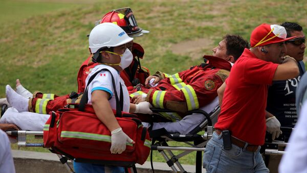 A fireman is evacuated during a fire at Larcomar mall in Lima, Peru - Sputnik International