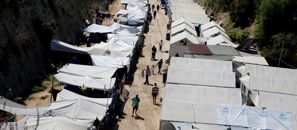 Refugees and migrants make their way at the Souda municipality-run camp, on the island of Chios, Greece, September 7, 2016 Refugees and migrants make their way at the Souda municipality-run camp, on the island of Chios, Greece, September 7, 2016 - Sputnik International