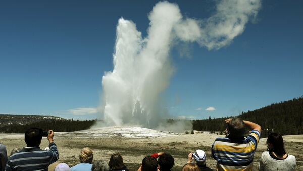 Tourists watch the 'Old Faithful' geyser which erupts on average every 90 minutes in the Yellowstone National Park, Wyoming on June 1, 2011 - Sputnik International