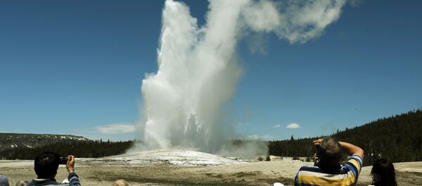 Tourists watch the 'Old Faithful' geyser which erupts on average every 90 minutes in the Yellowstone National Park, Wyoming on June 1, 2011 - Sputnik International