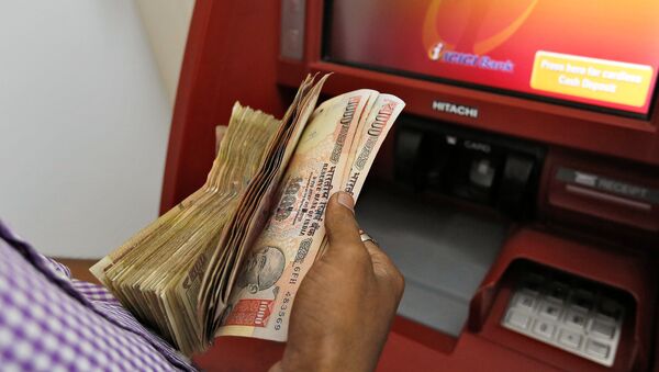 A customer deposits 1000 and 500 Indian rupee banknotes in a cash deposit machine at bank in Mumbai, India, November 8, 2016 - Sputnik International