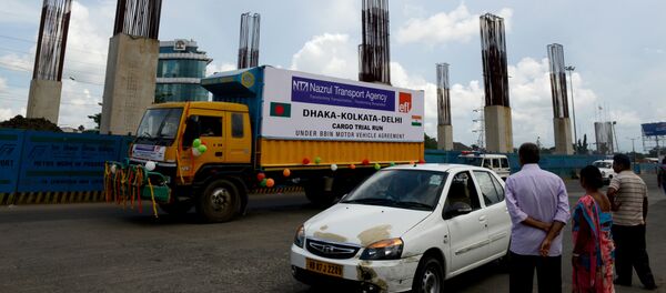 People on the road watch as a Bangladeshi cargo vehicle of the 'Dhaka-Kolkata-New Delhi' route begins its journey to Dhaka as part of the Bangladesh, Bhutan, India and Nepal (BBIN) Motor Vehicles Agreement, in Kolkata on August 30, 2016 - Sputnik International