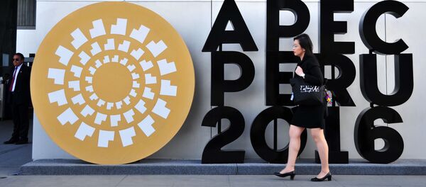 A woman walks by an APEC logo outside the Lima Convention Centre, during the Asia-Pacific Economic Cooperation (APEC) Summit on November 17, 2016 in Lima - Sputnik International