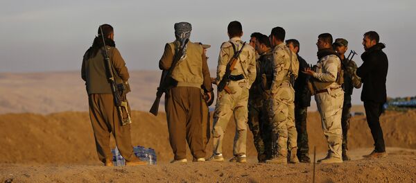 Kurdish Peshmerga fighters stand at a crossing point where Iraqis fleeing the fighting between Iraqi forces and Islamic State militants cross to the Kurdish controlled area, in the Nineveh plain, northeast of Mosul, Thursday, Nov. 17, 2016 - Sputnik International