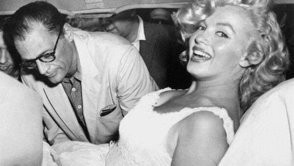 Marilyn Monroe is made comfortable in a car by her husband, playwright Arthur Miller, following her release from Doctors Hospital, New York City, August 10, 1957. - Sputnik International