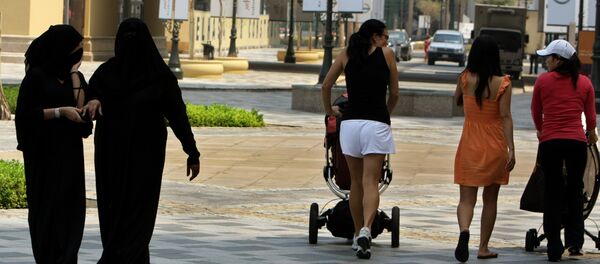 Foreign women walk past fully-veiled local women in the Gulf emirate of Dubai on September 15, 2010. Foreign women walk past fully-veiled local women in the Gulf emirate of Dubai on September 15, 2010. - Sputnik International