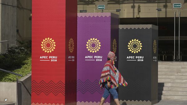 A man dressed in traditional Andean clothes walks past the logo of the APEC 2016 summit in Lima, Peru, Wednesday, Nov. 16, 2016 - Sputnik International