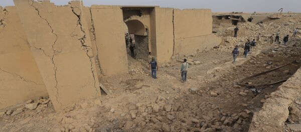 Iraqi soldiers and journalists walk in the damaged ancient site of Nimrud, which destroyed by the Islamic State militants, some 19 miles (30 kilometers) southeast of Mosul, Iraq, Wednesday, Nov. 16, 2016. - Sputnik International