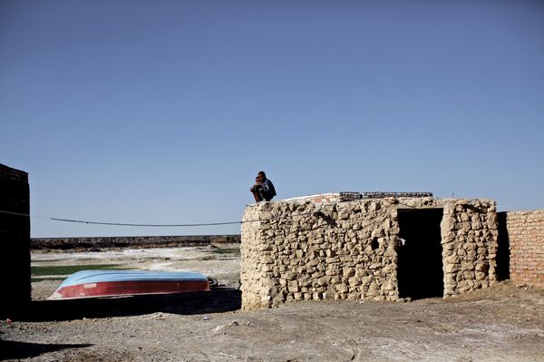 Iranian boys sit on the roof of a mud-house in Adimi village in Hamoon wetland near the Zabol town in southeastern province of Sistan-Baluchistan bordering Afghanistan on February 2, 2015. Iranian boys sit on the roof of a mud-house in Adimi village in Hamoon wetland near the Zabol town in southeastern province of Sistan-Baluchistan bordering Afghanistan on February 2, 2015. - Sputnik International