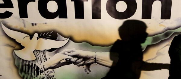 A shadow of a boy is seen on a banner showing the Cyprus island with two hands and a pigeon during a peace rally to support the peace talks inside the UN buffer zone Green Line, in the divided capital Nicosia in the eastern Mediterranean island of Cyprus, Monday, Nov. 21, 2016. Hundreds of Greek and Turkish Cypriots are demonstrating for peace as the ethnically divided island's rival leaders continue complex reunification talks at a Swiss resort. A shadow of a boy is seen on a banner showing the Cyprus island with two hands and a pigeon during a peace rally to support the peace talks inside the UN buffer zone Green Line, in the divided capital Nicosia in the eastern Mediterranean island of Cyprus, Monday, Nov. 21, 2016. Hundreds of Greek and Turkish Cypriots are demonstrating for peace as the ethnically divided island's rival leaders continue complex reunification talks at a Swiss resort. - Sputnik International