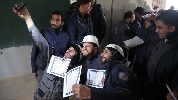 Members of the Syrian Civil Defence, known as the White Helmets, take a selfie with their certificates after taking part in a training session in the rebel-held eastern Ghouta area, east of the capital Damascus, on November 22, 2016 - Sputnik International