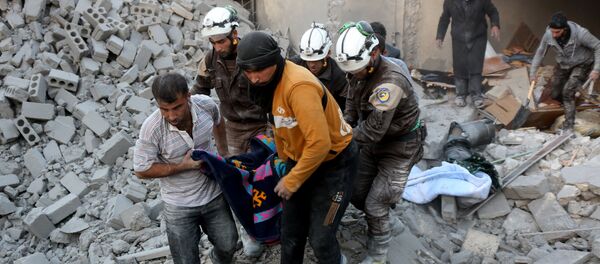 Syrian civil defence volunteers, known as the White Helmets, evacuate a victim from the rubble of a building following reported airstrikes on Aleppo's rebel-held district of al-Hamra on November 20, 2016 Syrian civil defence volunteers, known as the White Helmets, evacuate a victim from the rubble of a building following reported airstrikes on Aleppo's rebel-held district of al-Hamra on November 20, 2016 - Sputnik International