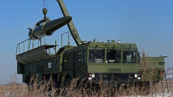 A transporter-loader places an Iskander-M shorter-range missile onto a self-propelled launcher during an exercise involving missile and artillery units of the Eastern Military District's Fifth Russian Army in the Primorye Territory - Sputnik International
