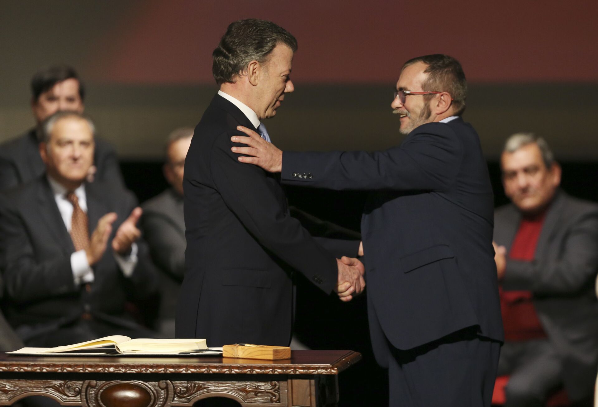 Colombia's President Juan Manuel Santos, left, shakes hands with with Rodrigo Londono, known as Timochenko, the top leader of the Revolutionary Armed Forces of Colombia, FARC, after signing a revised peace pact at Colon Theater in Bogota, Colombia, Thursday, Nov. 24, 2016 - Sputnik International, 1920, 24.11.2021