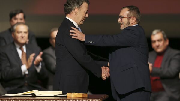 Colombia's President Juan Manuel Santos, left, shakes hands with with Rodrigo Londono, known as Timochenko, the top leader of the Revolutionary Armed Forces of Colombia, FARC, after signing a revised peace pact at Colon Theater in Bogota, Colombia, Thursday, Nov. 24, 2016 - Sputnik International