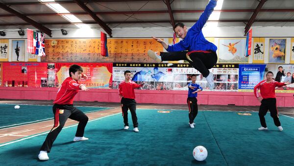 Martial arts students at a Kung fu school in the northern suburbs of Beijing practice their technique leaping over a soccer ball (File) - Sputnik International