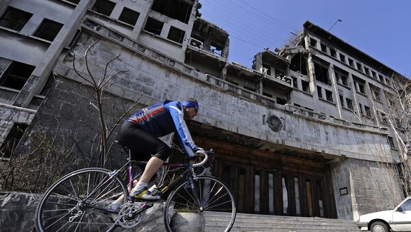 A man rides his bike on March 22, 2009 past the building of the former federal Interior Ministry in Belgrade, which was destroyed during the 1999 NATO air campaign against Serbia and Montenegro - Sputnik International