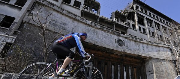 A man rides his bike on March 22, 2009 past the building of the former federal Interior Ministry in Belgrade, which was destroyed during the 1999 NATO air campaign against Serbia and Montenegro - Sputnik International