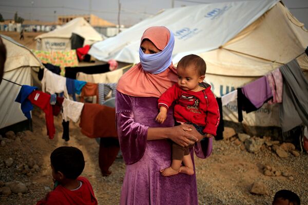 A woman who fled from Mosul carries her five-month-old daughter Ritadj, who was born under Islamic State rule and has no identity documents recognised by Iraqi authorities, in Debaga refugee camp, Iraq November 10, 2016 - Sputnik International