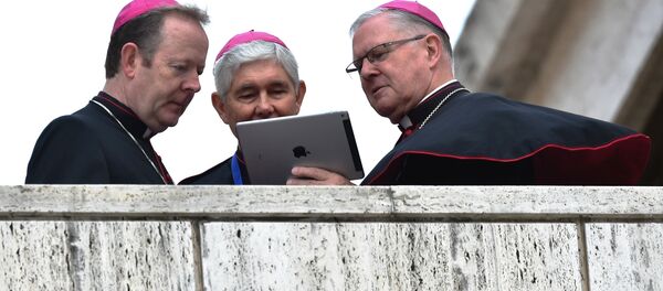 Bishops looks at the screen of a tablet as they await the arrival of the Pope for the Synod on the family at the Vatican on October 15, 2015. Bishops looks at the screen of a tablet as they await the arrival of the Pope for the Synod on the family at the Vatican on October 15, 2015. - Sputnik International