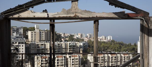 The Mediterranean sea and parts of the city can bee sen through a burned house following wildfires in Haifa, Israel, Friday, Nov. 25, 2016. Israeli firefighters reined in a blaze that had spread across the country's third-largest city and forced tens of thousands of people to flee their homes, but continued to battle more than a dozen other fires around the country for the fourth day in a row. The Mediterranean sea and parts of the city can bee sen through a burned house following wildfires in Haifa, Israel, Friday, Nov. 25, 2016. Israeli firefighters reined in a blaze that had spread across the country's third-largest city and forced tens of thousands of people to flee their homes, but continued to battle more than a dozen other fires around the country for the fourth day in a row. - Sputnik International